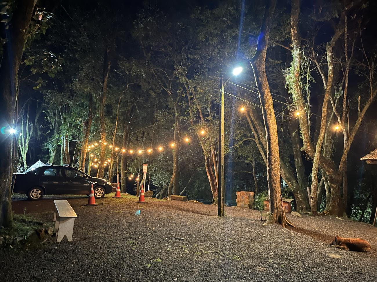 Estacionamento iluminado à noite com varal de luzes