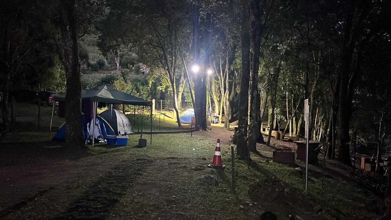 Barracas e gazebo iluminados por refletores à noite
